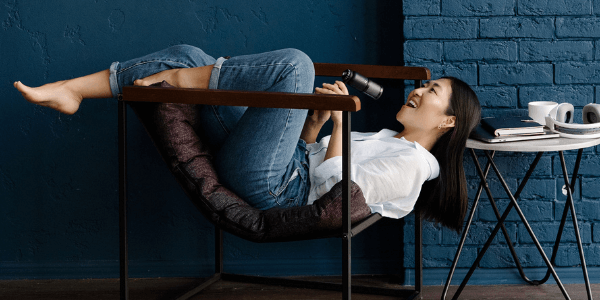 Woman relaxes in chair facing backward with feet up