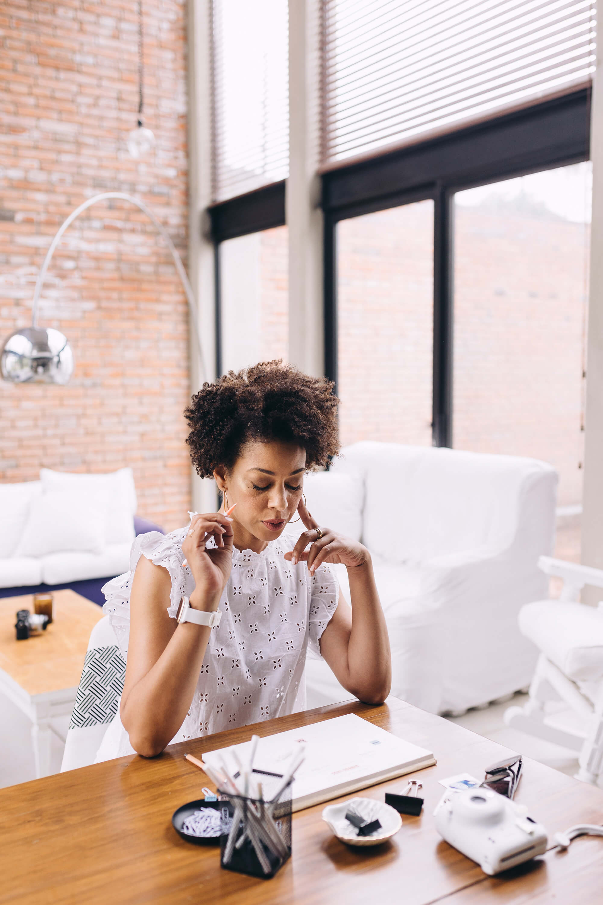 Woman sits at a desk focused on the paper in front of her.